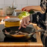 Frau kocht auf Kochfeld