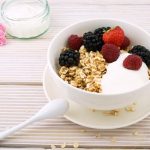 Müslischale mit frischen Früchten undLöffel